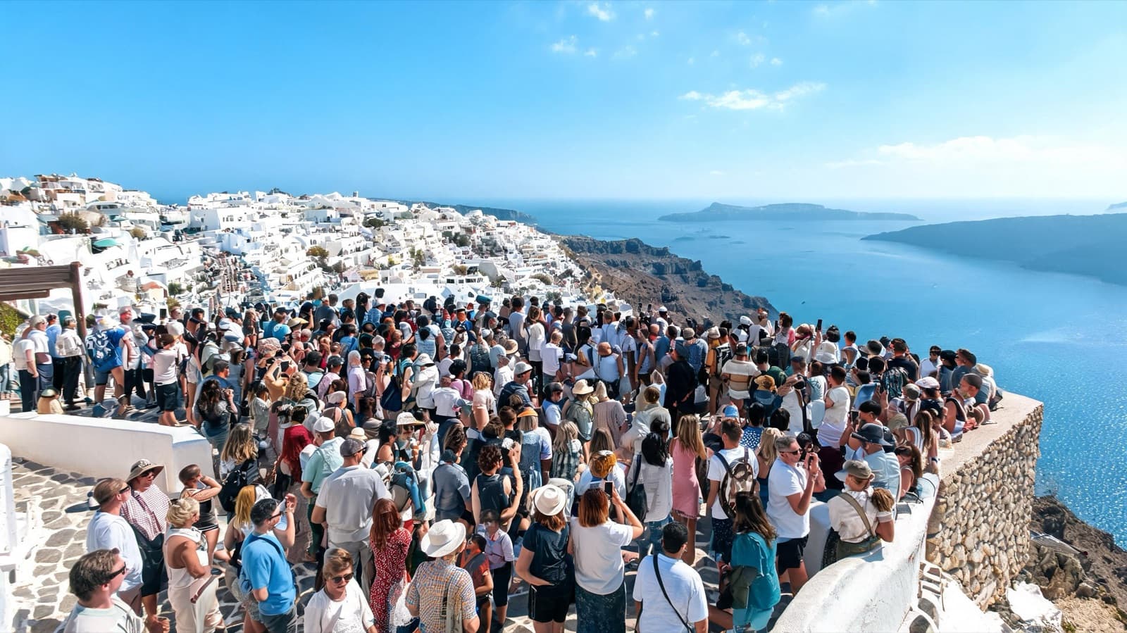 Crowded famous viewpoint at midday with many tourists, wide documentary-style travel photo